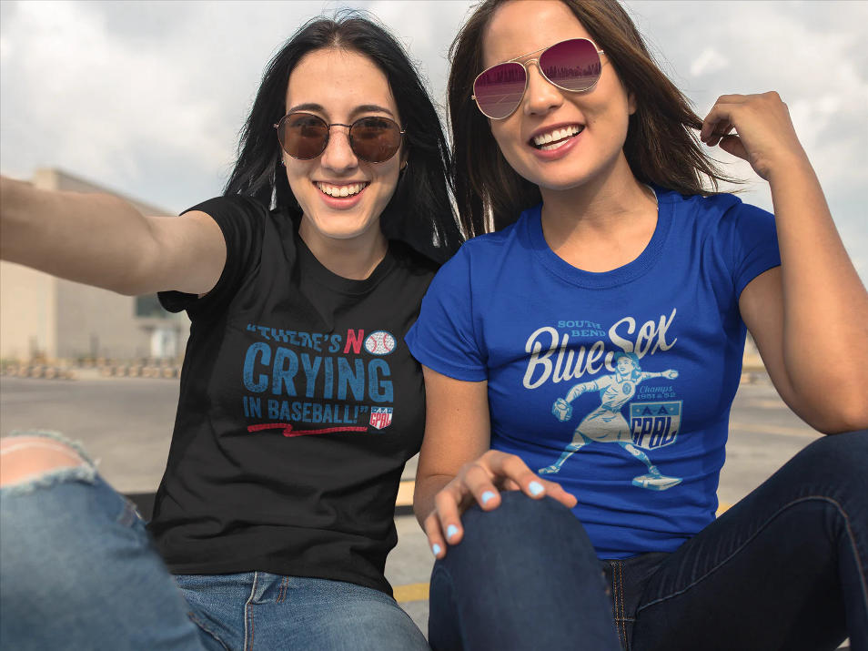 Two women wearing cute baseball shirts for ladies, smiling outdoors.